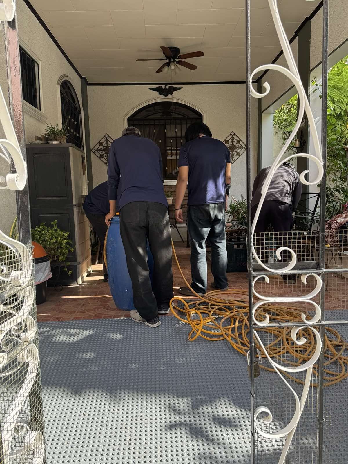 Novee team setting up spray equipment on a home porch